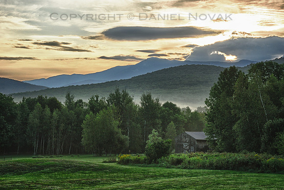 A barn in Green Mountains at Sunrise, layer of distant fog, Vermont (VT).