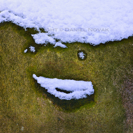 The Snowrock Man, a face made of rock and a snow hat, eyes, and mouth, maybe even a tear. Chestnut Ridge, Orchard Park, New York (NY).