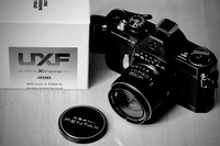 Black Asahi Pentax Spotmatic F, a vintage 35mm Film Camera and a box of 100 feet of Ultrafine Xtreme UXF400 film for bulk loading.