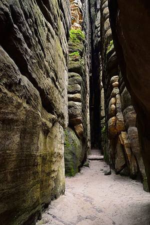 Rock walls rising high around narrow passages in Teplice Rocks (Teplické skály), Czech Republic
