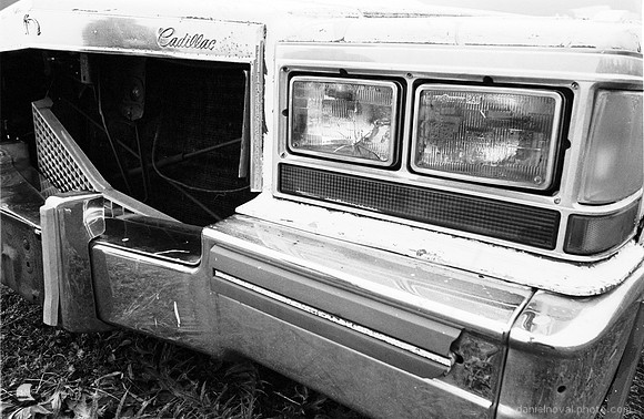 An old vintage and decaying Cadillac close-up on Kodak 5222 black and white film