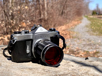 35mm Asahi Pentax Spotmatic SP film camera, Super-Takumar 105mm f/2.8 lens, 49mm to 52mm step-up ring, red Hoya 52mm filter.