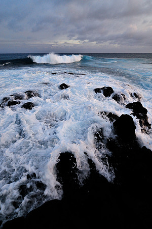 Surf and waves rushing and crashing on the lava rocks of Poipu Beach, South Shore Kauai, Hawaii (HI).