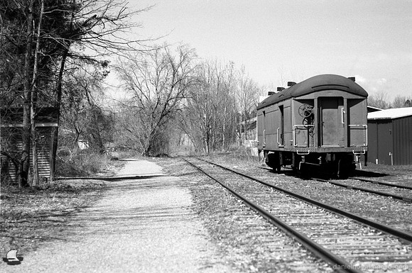 Rails to Trails behind the Train Depot, Orchard Park, NY. An old-fashioned black and white analog photograph captured with a 35mm Pentax Spotmatic camera on Kodak T-Max 100 negative film.