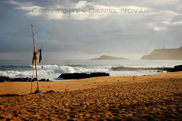 Misty sunrise and a totem pole at Secret Beach, north Shore Kauai, Hawaii (HI).